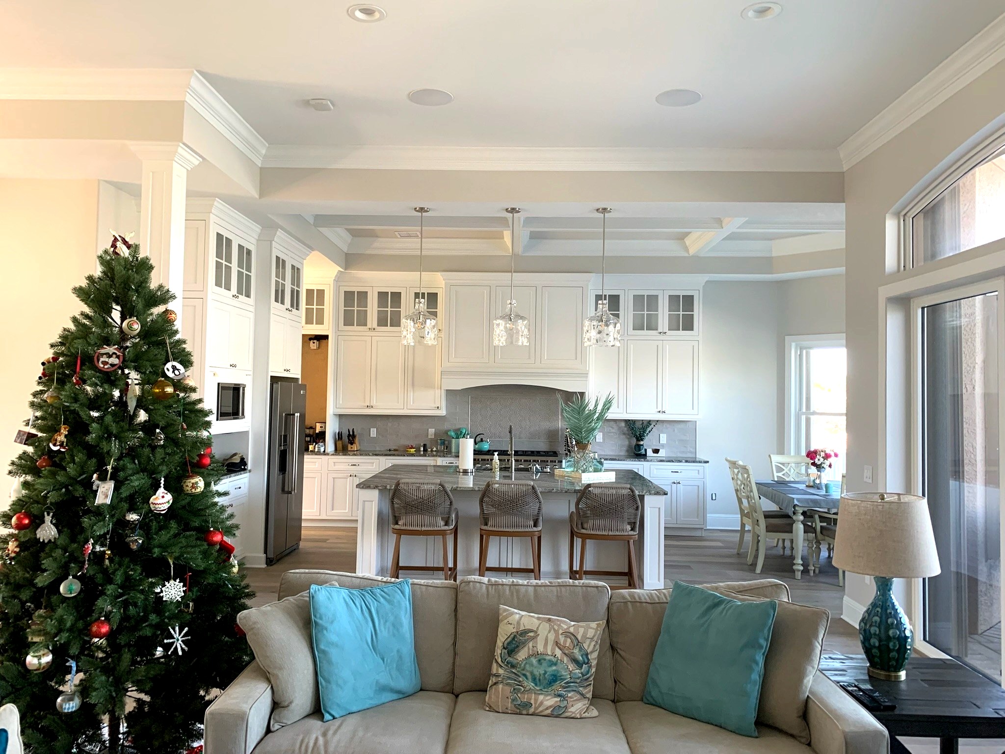Open-concept kitchen remodel with white cabinetry, granite island, and pendant lighting